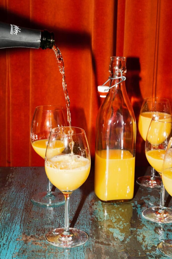 Mimosa's worden ingeschonken met verse jus d'orange